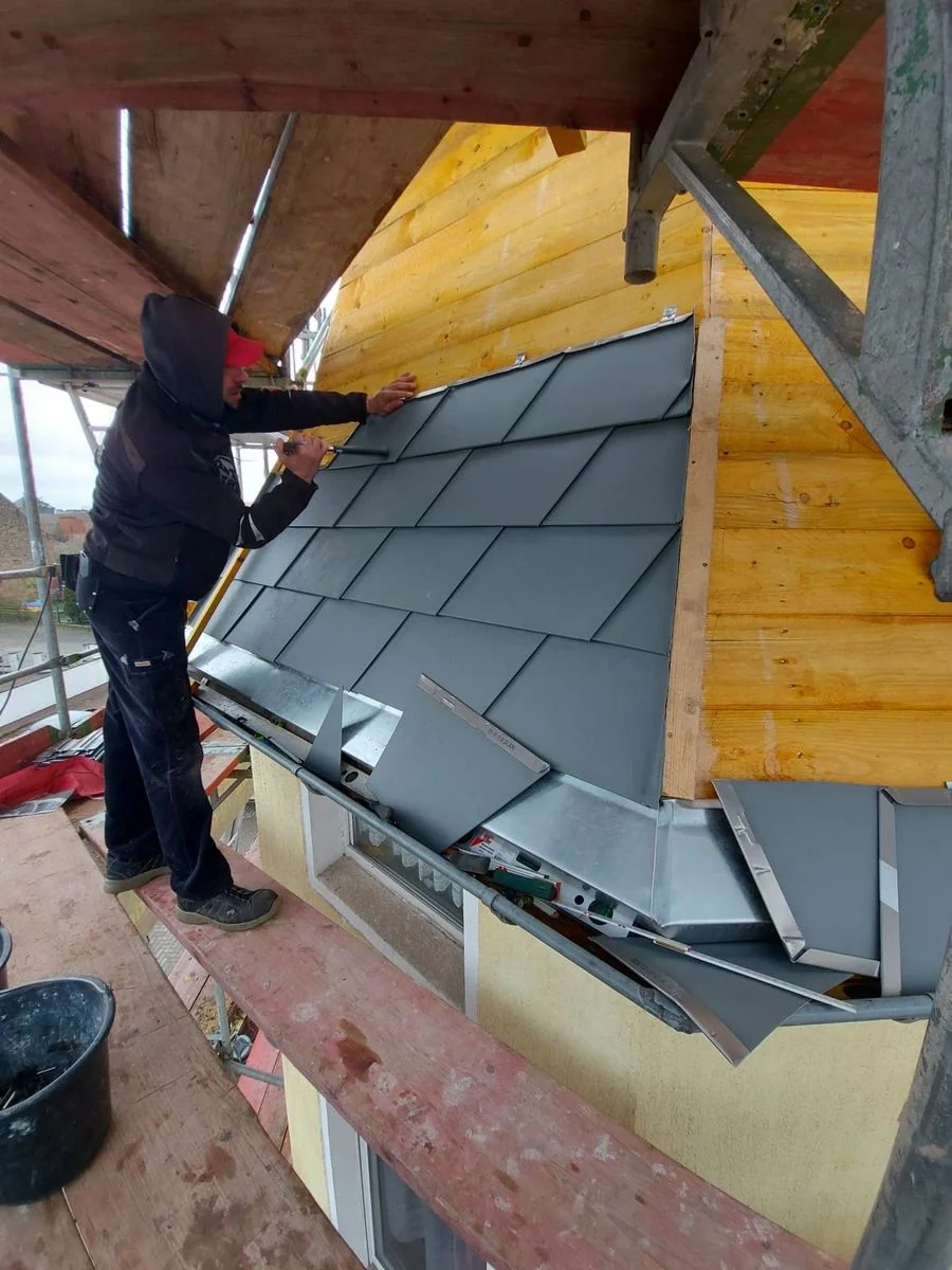 Handwerk im Detail: Ein Dachdecker arbeitet an der Turmdeckung
